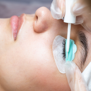 Detailaufnahme einer Lash-Lifting-Behandlung: Kundin mit Eyepatches und Lifting-Pads, während die Naturwimpern sanft nach oben gebürstet und mit Kleber fixiert werden – Beauty-Treatment in Glashütten und Eppstein