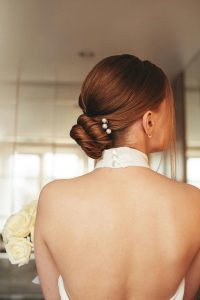 Moderne Brautfrisur 2026 mit sleekem Dutt und elegantem Haarschmuck von schmuckblüte.de – aktuelle Trends für Bräute