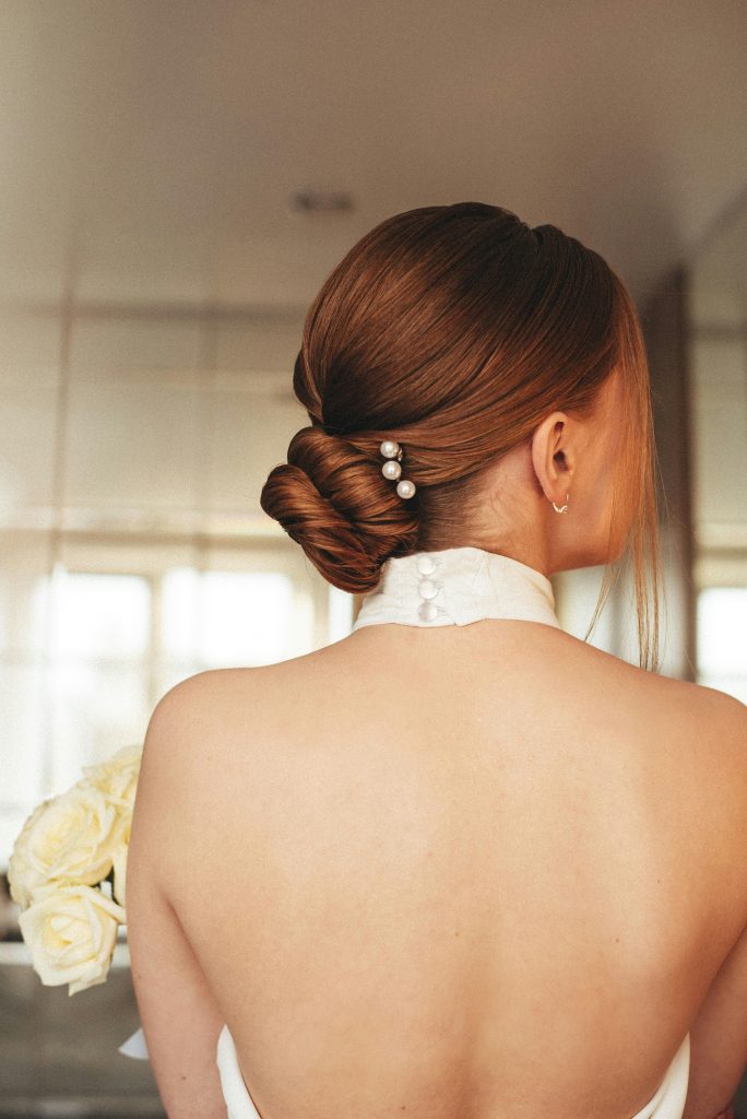 Moderne Brautfrisur 2026 mit sleekem Dutt und elegantem Haarschmuck von schmuckblüte.de – aktuelle Trends für Bräute