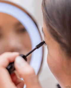 Nahaufnahme geschwungener, getuschter Wimpern beim Auftragen von Mascara