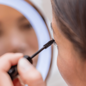 Nahaufnahme geschwungener, getuschter Wimpern beim Auftragen von Mascara