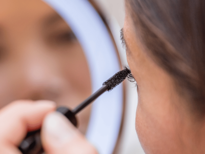 Nahaufnahme geschwungener, getuschter Wimpern beim Auftragen von Mascara