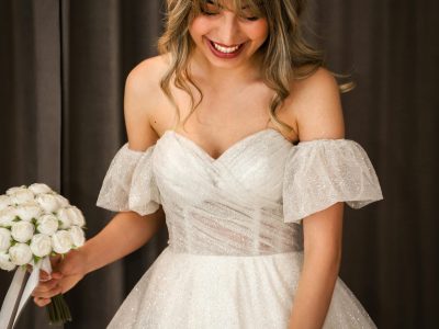 Eine strahlende, glückliche Braut in ihrem wunderschönen Hochzeitskleid, bereit für ihren großen Moment – voller Freude und Vorfreude auf den Beginn eines neuen Kapitels.
